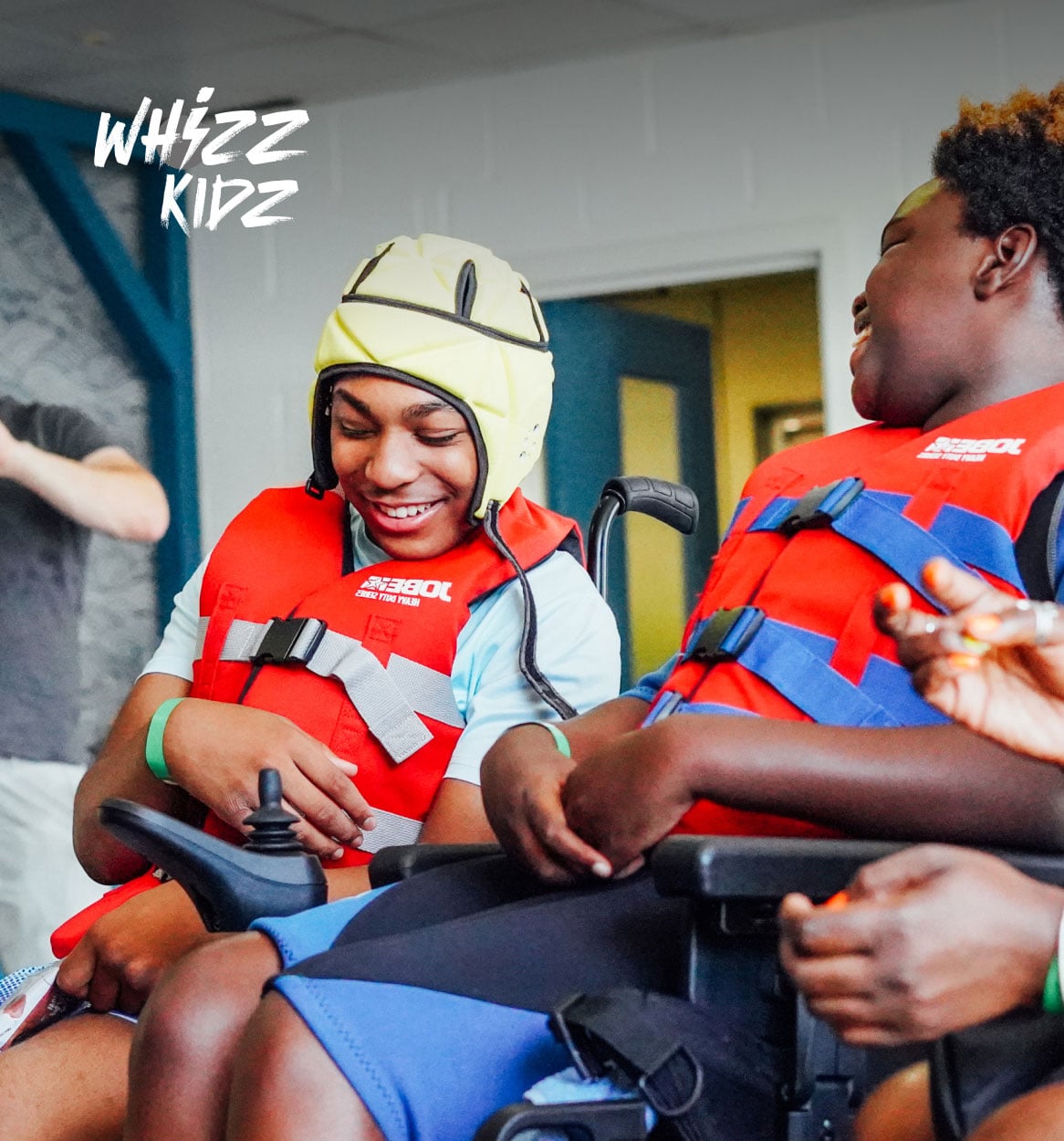 Two wheelchair users smiling.